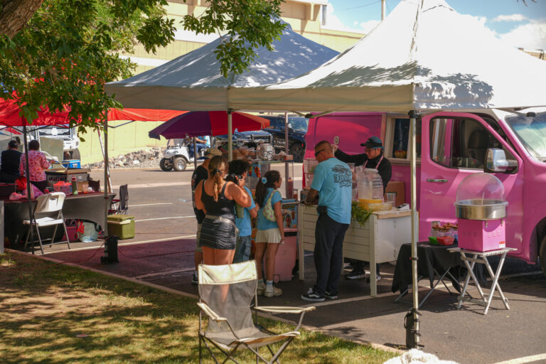 Guests lining up at the pink Chuchulucos food truck and tent at an outdoor event